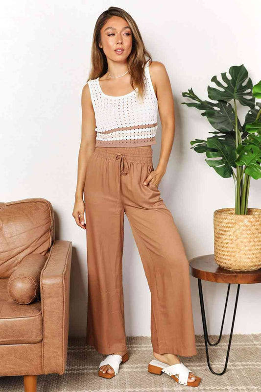 Crafted with a drawstring-smocked waist, these Women's wide-leg pants offer comfort and a flattering silhouette. Their extended length exudes elegance, making them suitable for casual or formal settings. Effortlessly stylish and versatile, these pants are an excellent choice for creating trendy yet comfortable ensembles.